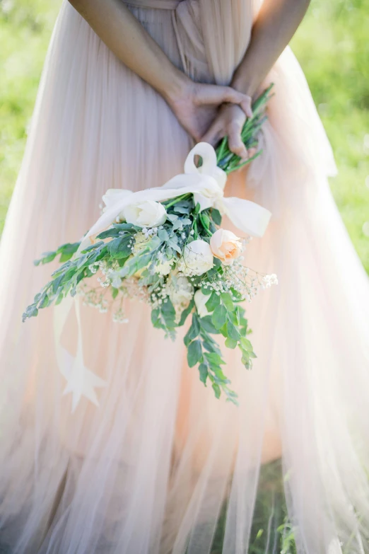 a bride holding her wedding bouquet in her hand