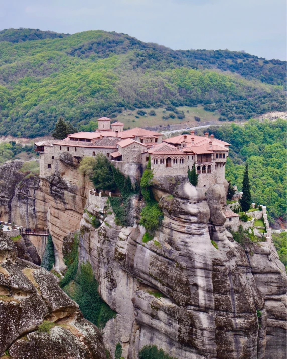 a house perched on a cliff with a village below