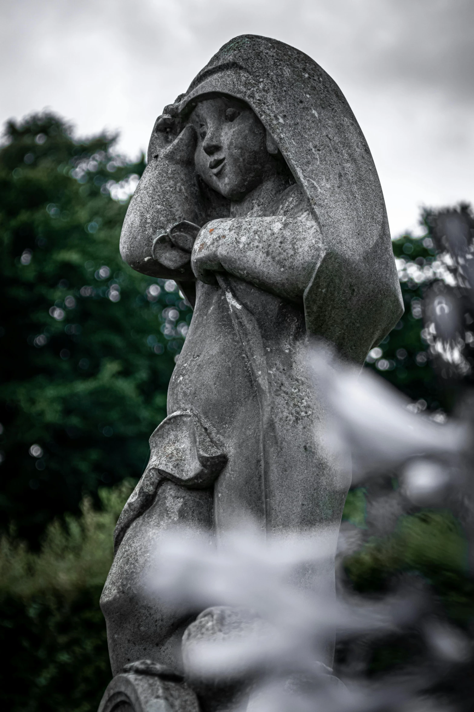 a statue made to look like an angel hugging the head of a boy