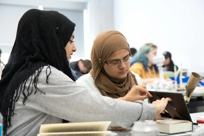 women looking at electronic devices in classroom setting