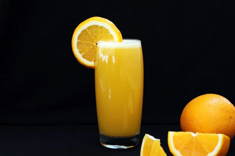 there are oranges and a glass with juice