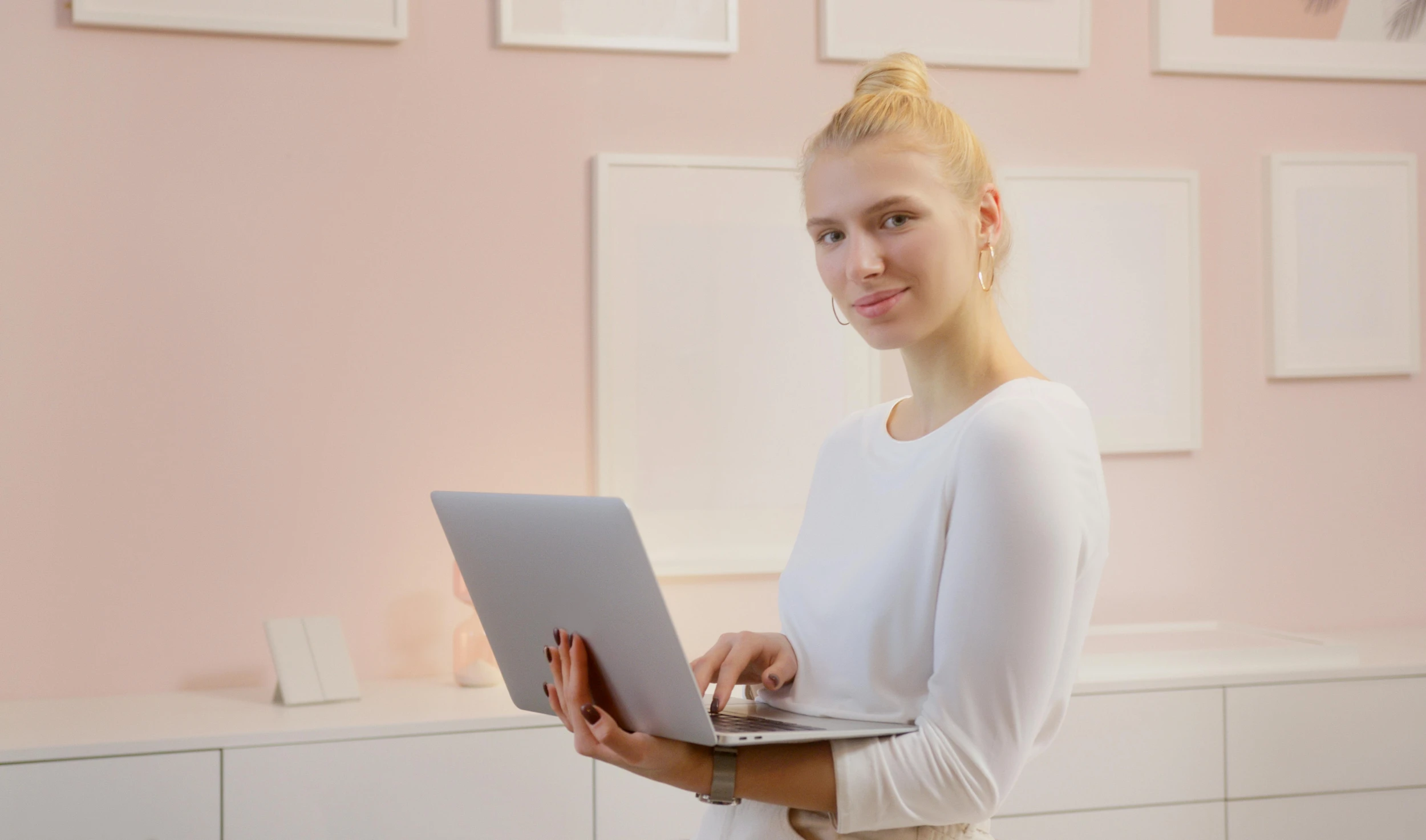 a young woman holding up a laptop computer