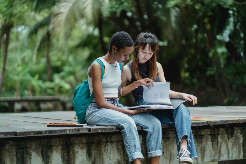 two s sitting on a stone wall and writing