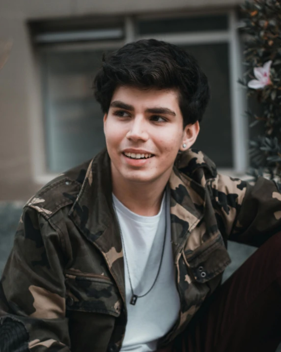 a young man in a camo jacket smiling