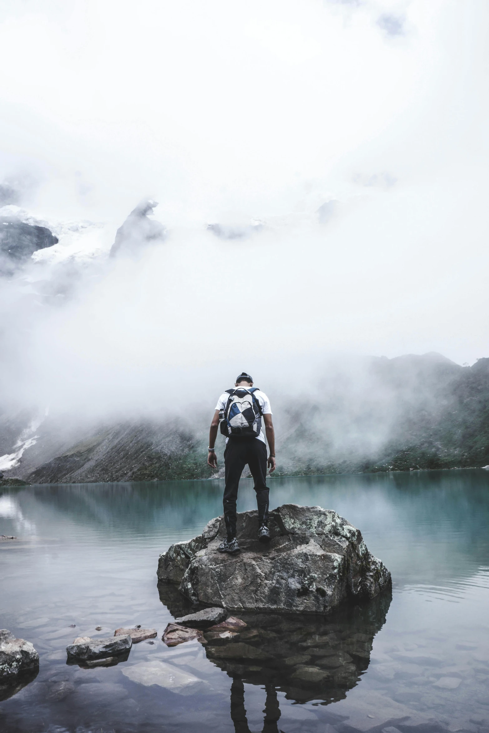 a man standing on the edge of a lake