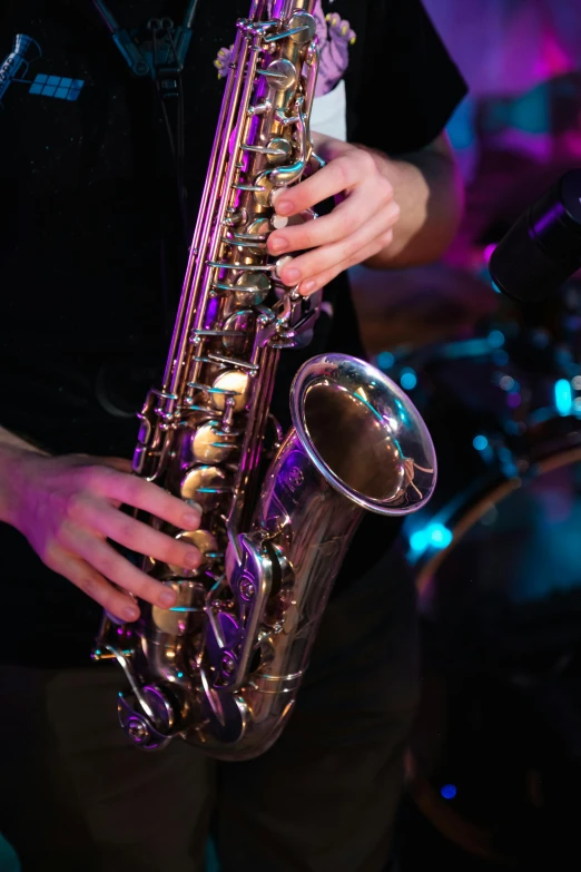 man playing on a saxophone while holding it up