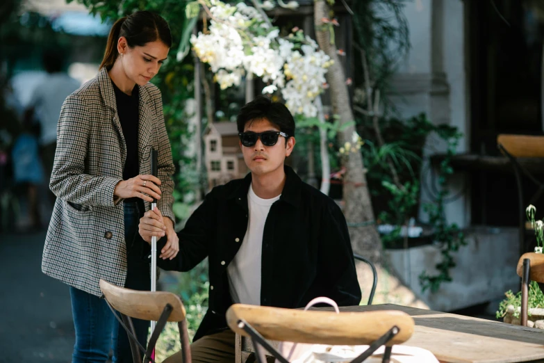 two people in black jackets and white shirts sitting at a table