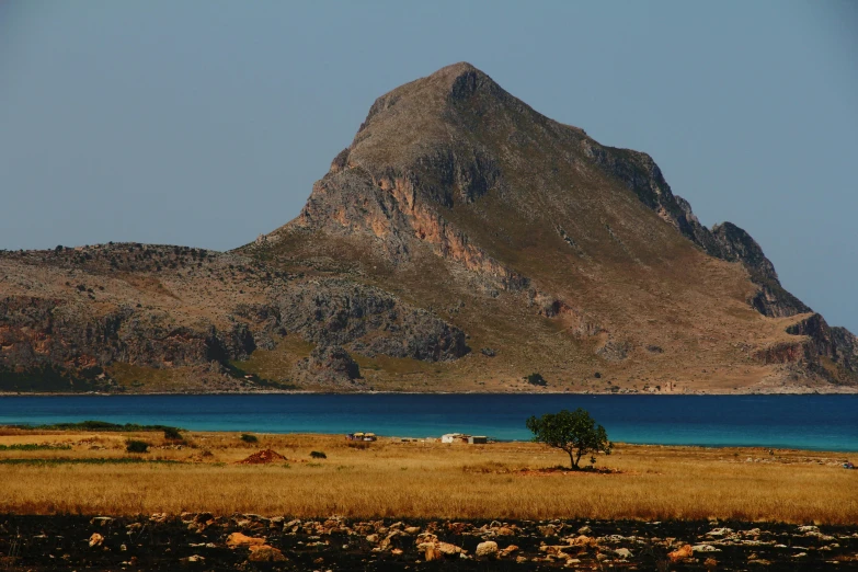 the landscape of the island is brown with blue water