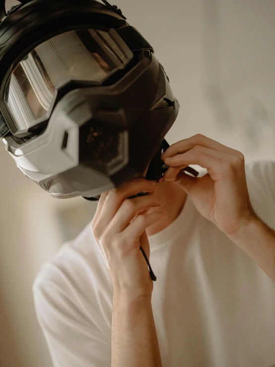 man adjusting a helmet on another person's face