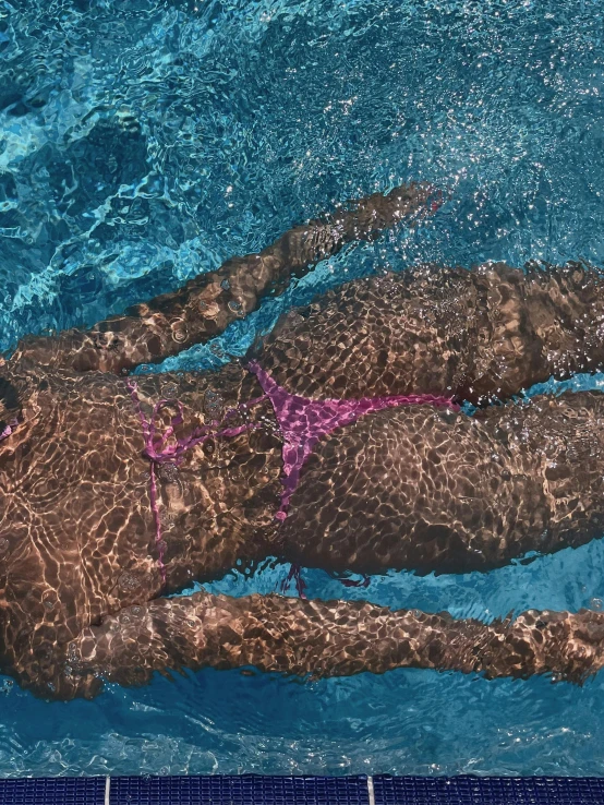 a man is swimming in the water wearing pink sunglasses