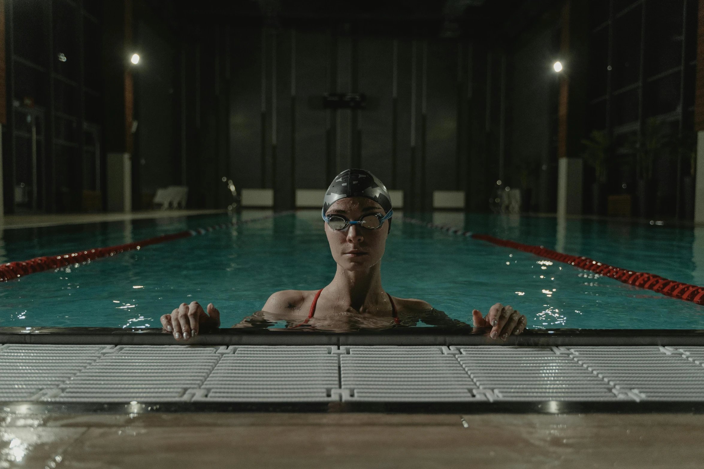 a young person is sitting in a pool looking at a camera