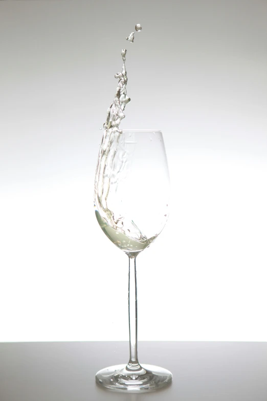 a wine glass splashes into the water