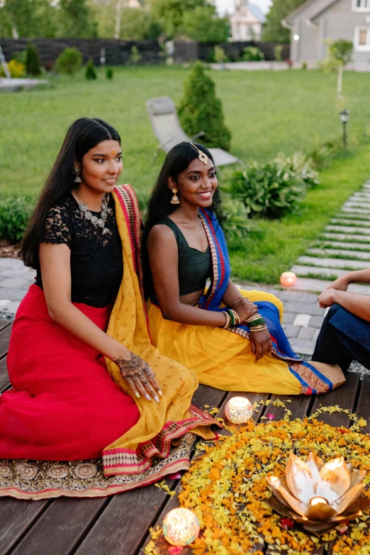 two ladies sitting on the ground with lights on