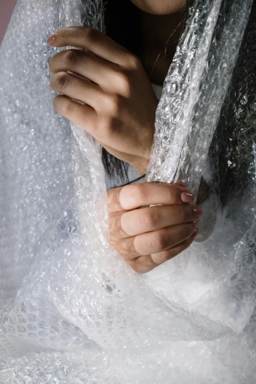 a woman in white and red holds her arm over the clear fabric