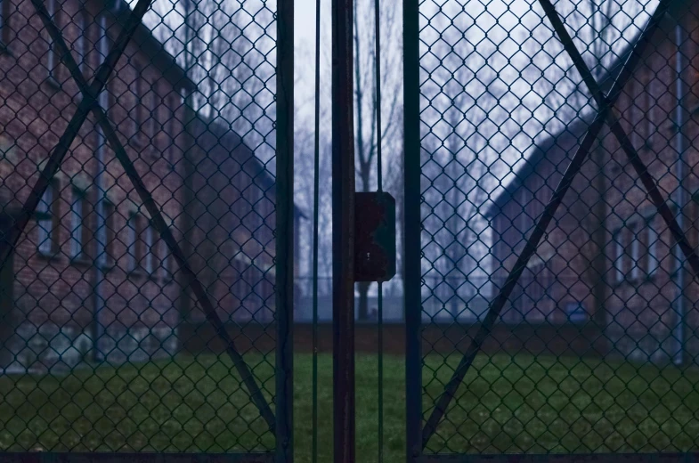 a gate is shown behind an iron fence with a stop sign