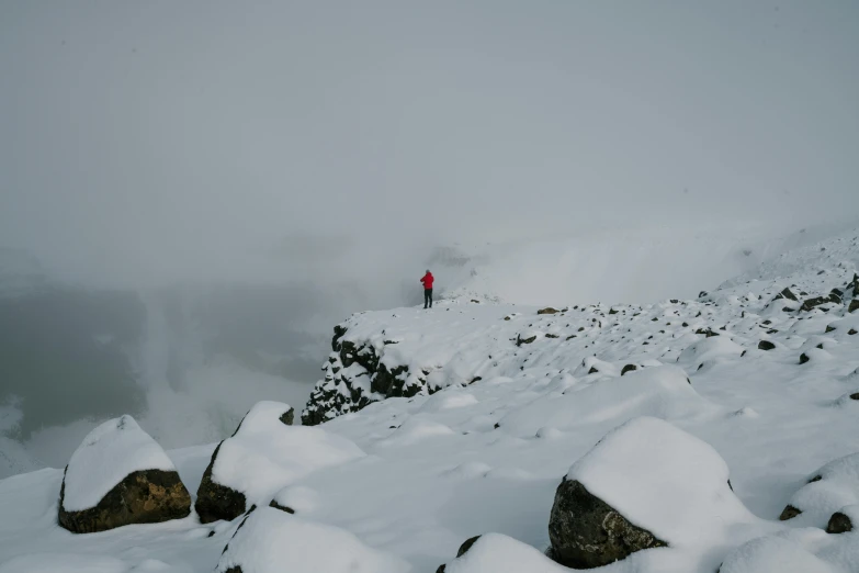 man standing on a snow covered mountain peak with skis