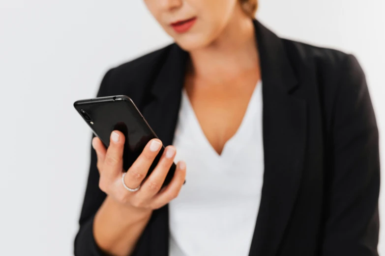 woman in black blazer texting on her cell phone