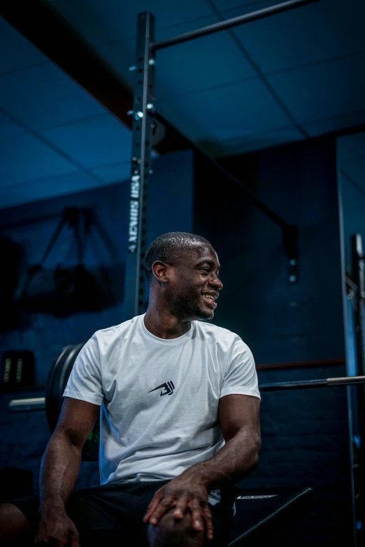 a man with an intense smile is sitting in the gym