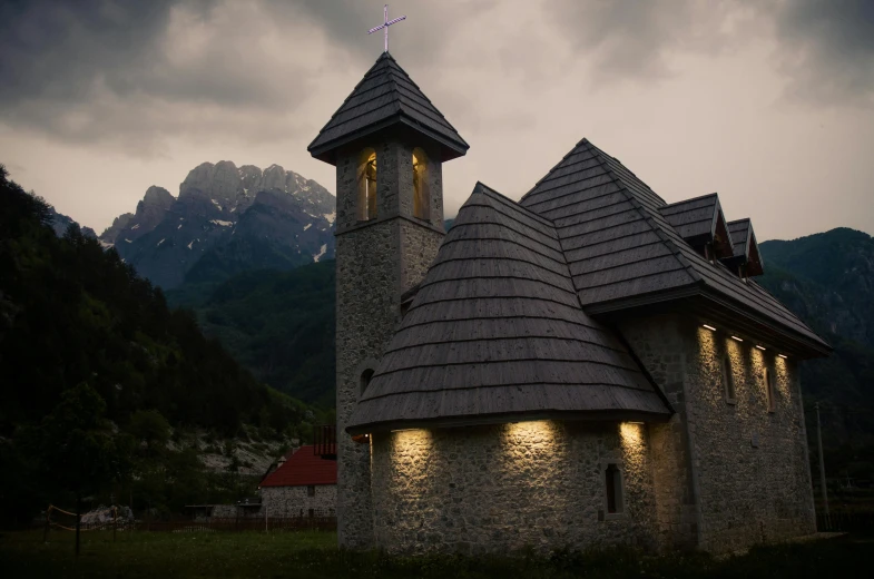 two towers with clocks on their sides lit up against the cloudy sky