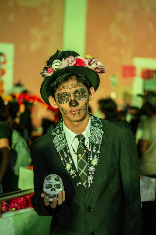a person in a costume and makeup is holding a skull
