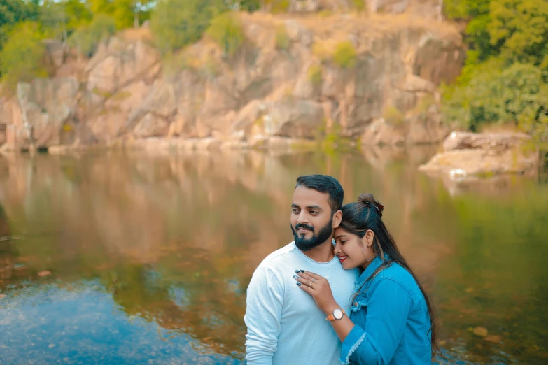 a man and woman emcing in front of the water