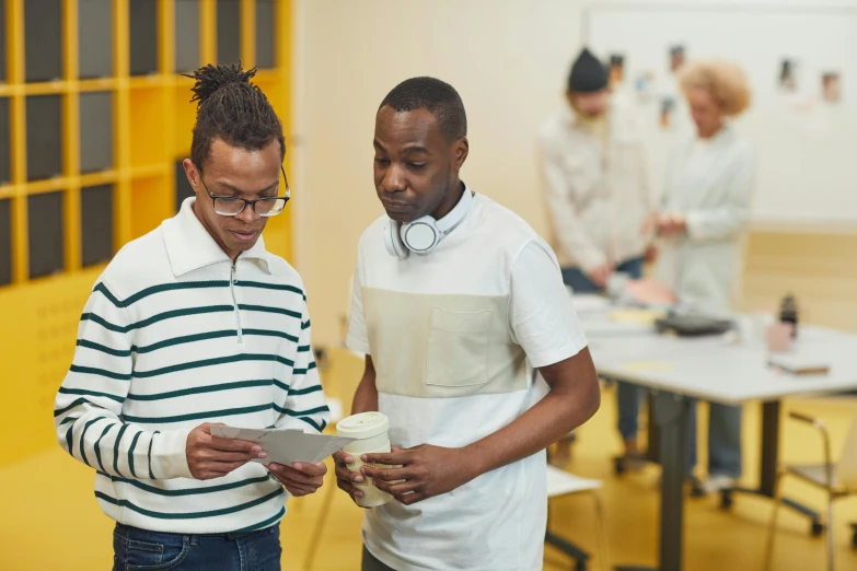 two men at an event, one looking at a piece of paper