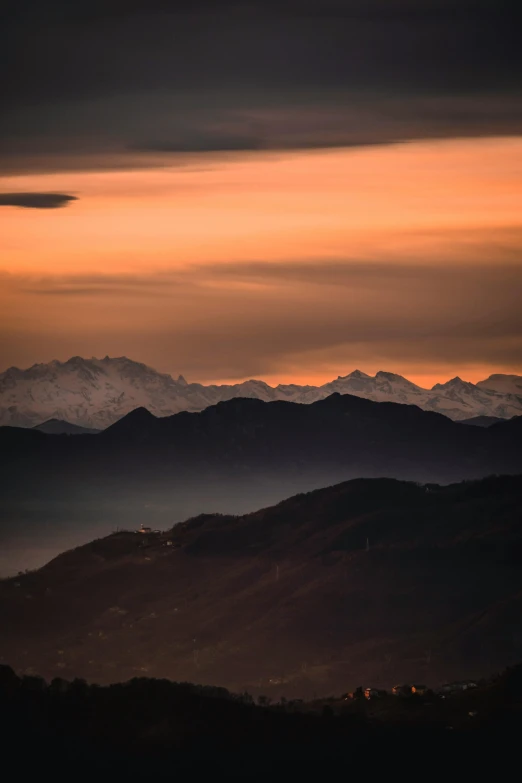 a long mountain range sits in front of some clouds