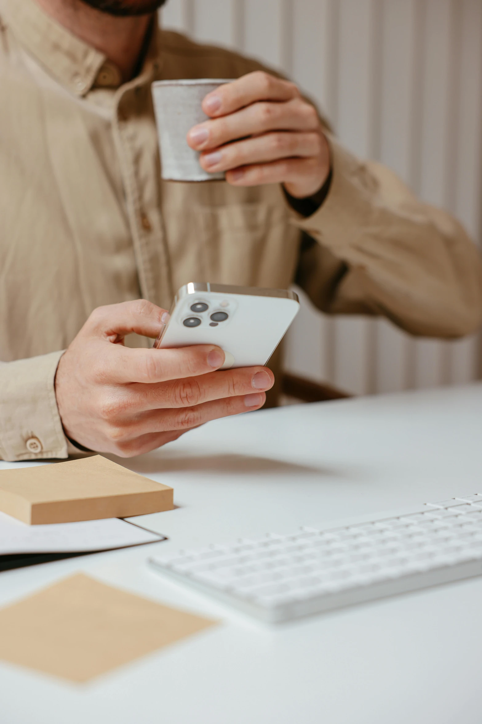 a man is sitting at the desk with his phone in hand