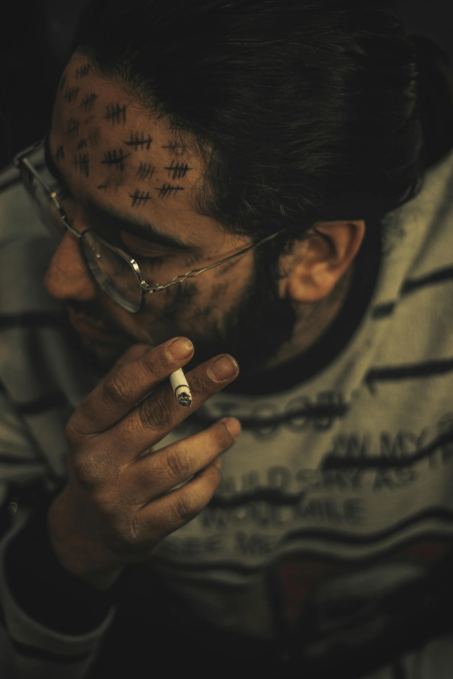 a man with all over his face is smoking a cigarette