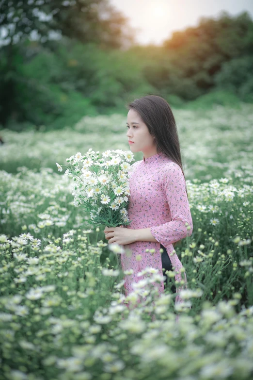 a girl in a field with flowers looking into the distance