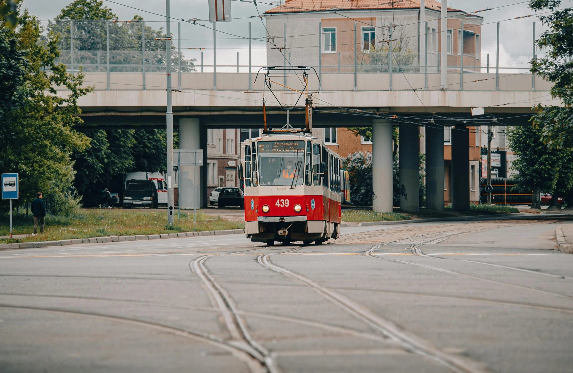 the red train is traveling under a bridge