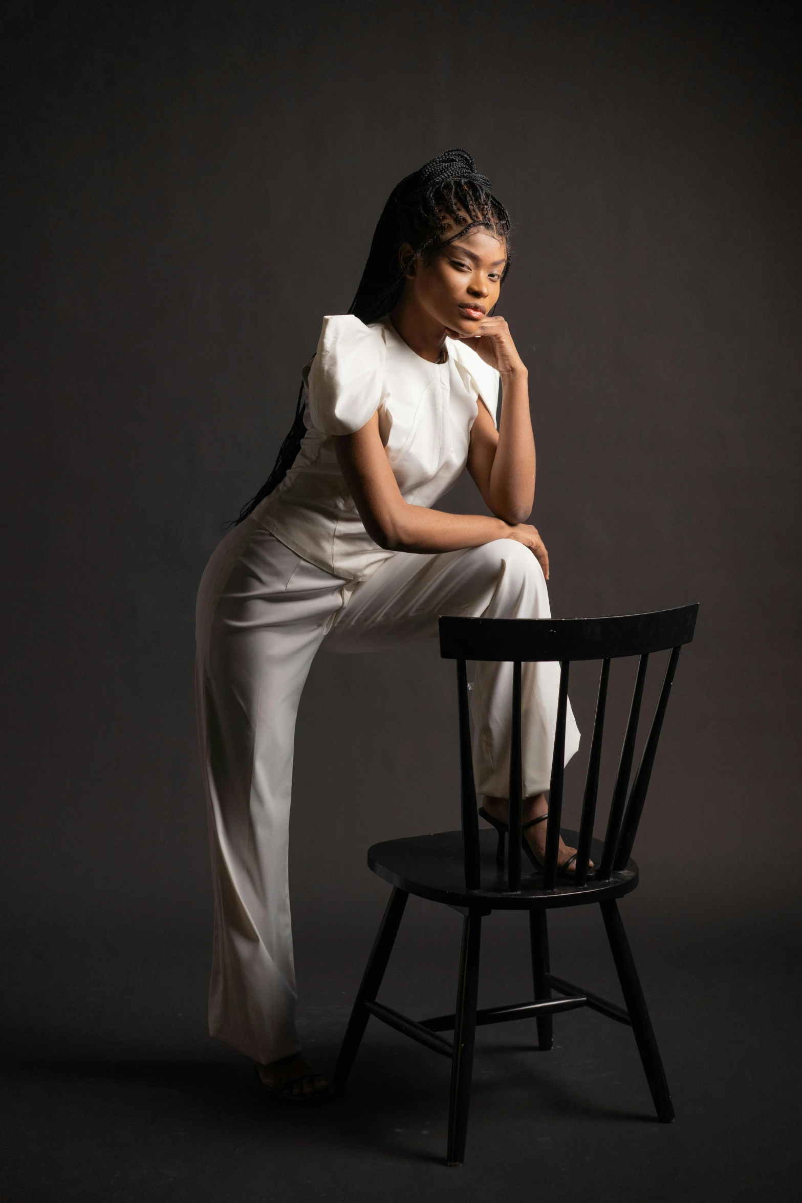 woman sitting in chair looking down posing for the camera