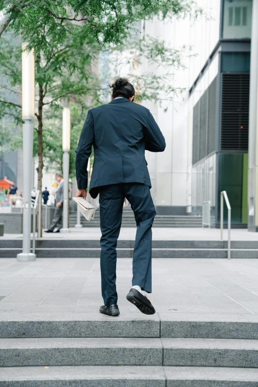 a man in business attire walking on concrete stairs