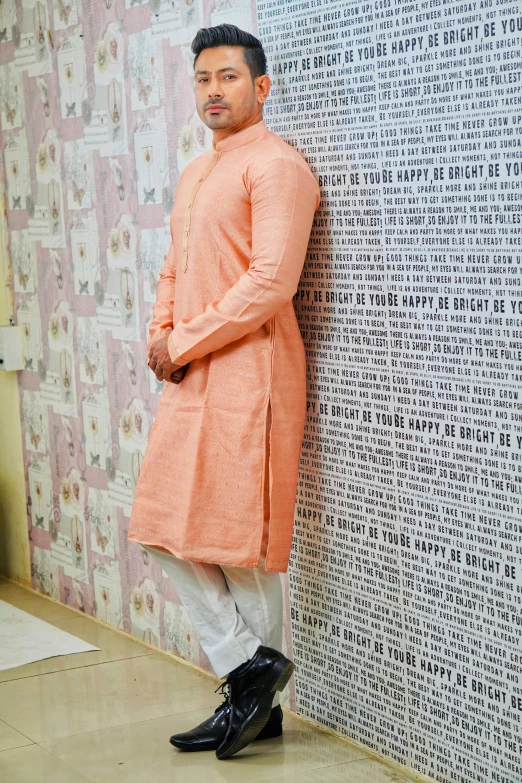 man standing against a wall with a large fabric on it