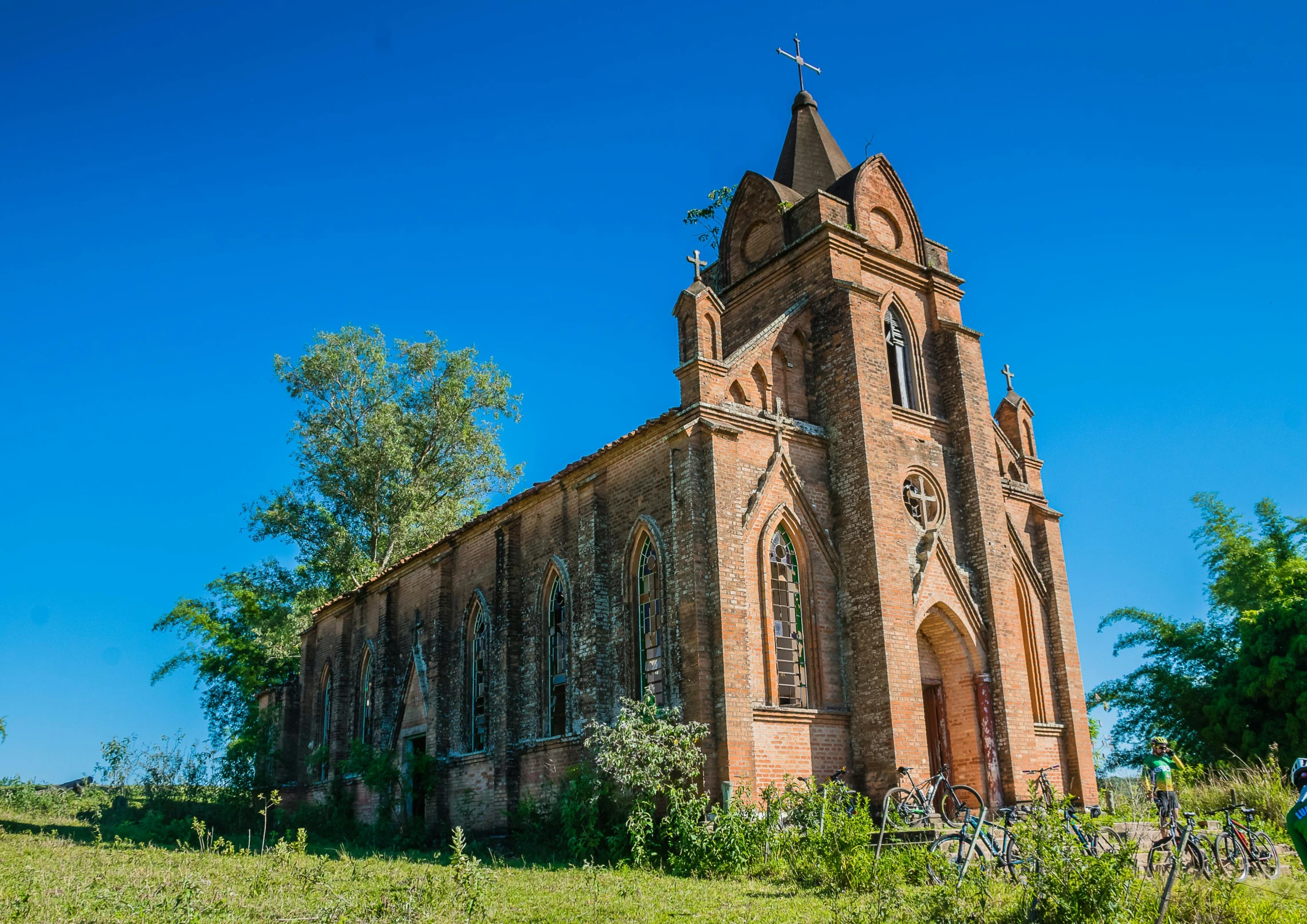 a church steeple in a grassy field with flowers