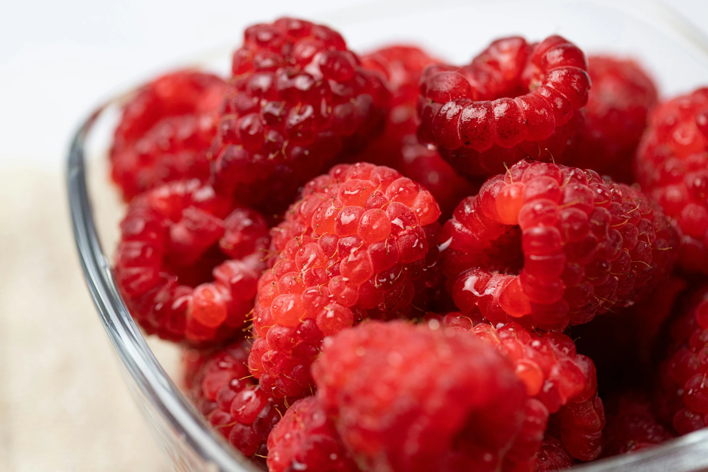 a close up of berries in a clear glass dish