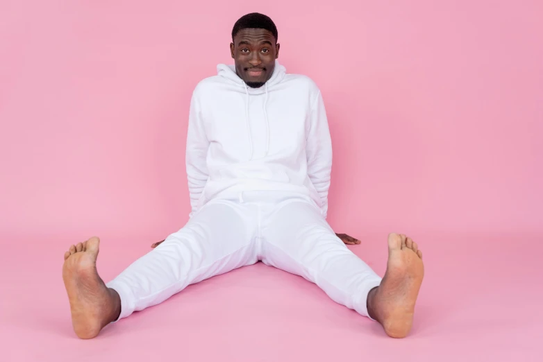 a man with black hair in a white outfit, posing for a po