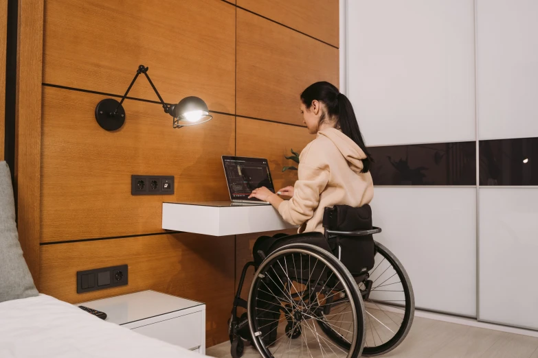 a person in a wheelchair on a laptop