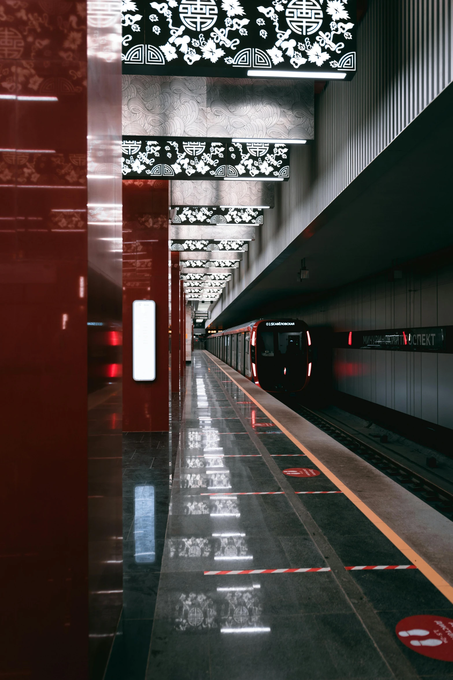 a train pulling up to a station with red lights