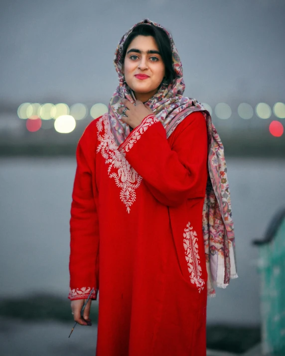 an indian woman standing in front of a body of water