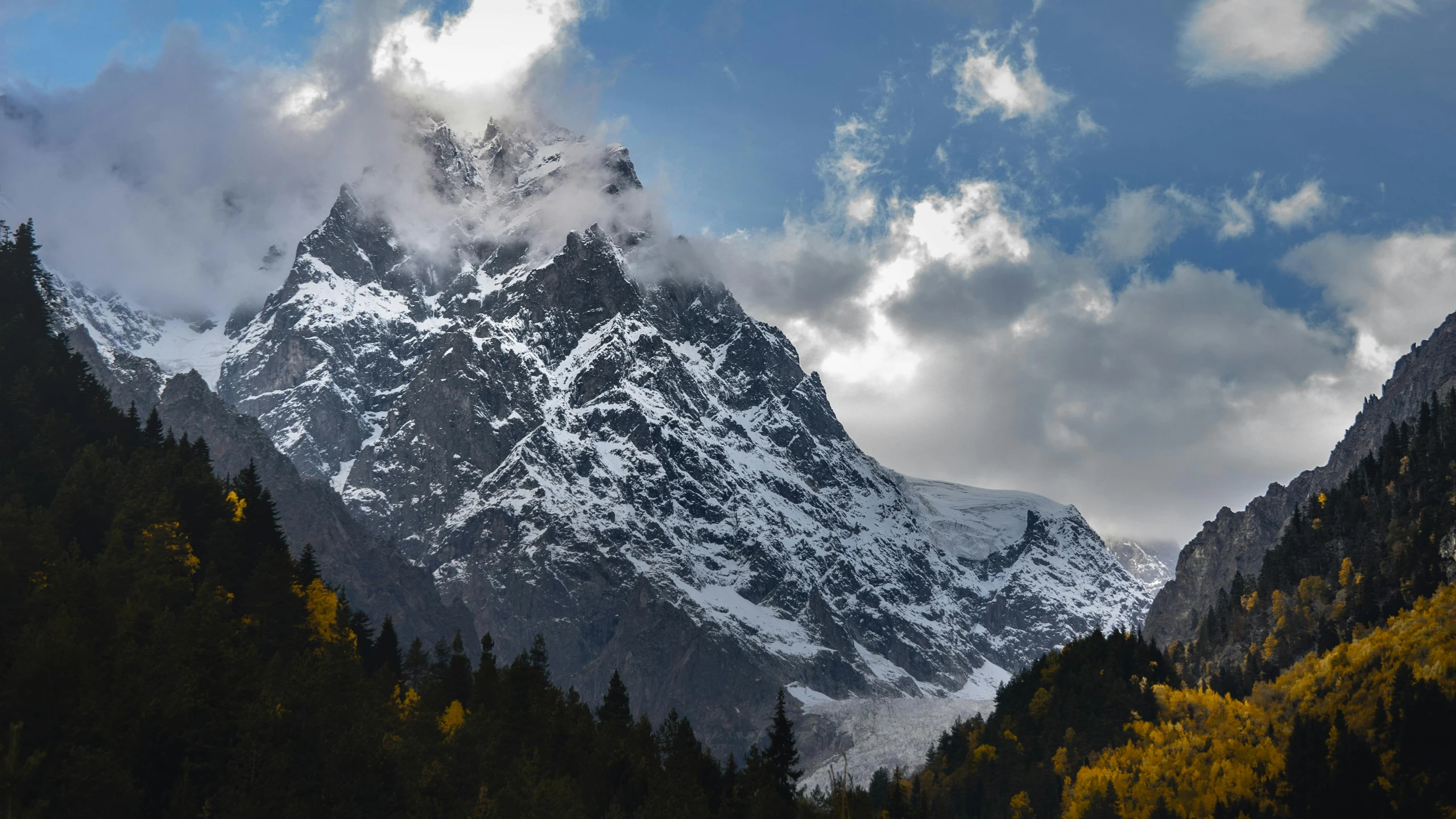 clouds drift over the mountains and trees during fall