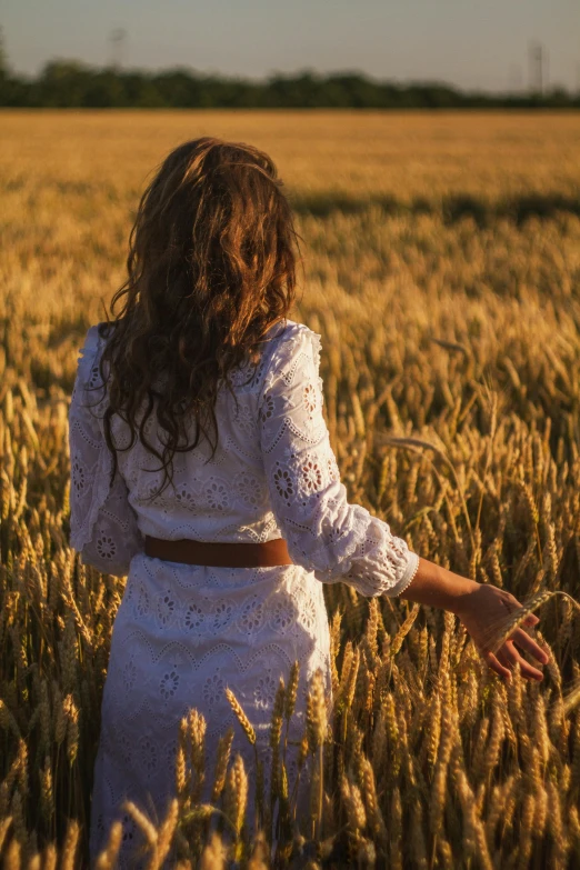 a woman standing in a field in the sun