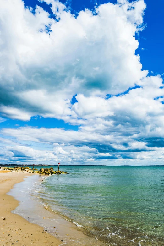 some kind of blue sky and white clouds with a lone sail boat in the water