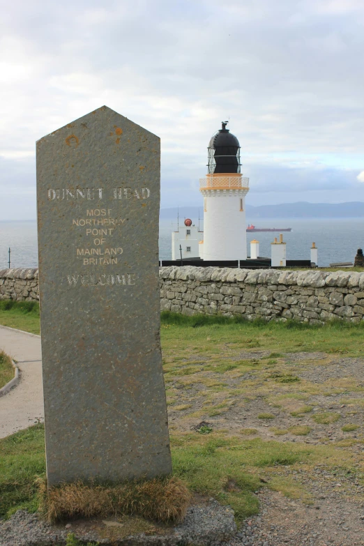 a large stone monument standing next to a lighthouse
