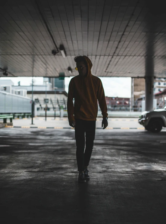 a person walking in a parking lot wearing a sweater