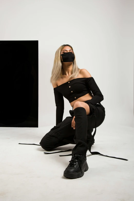 the woman is kneeling down and wearing a blindfold