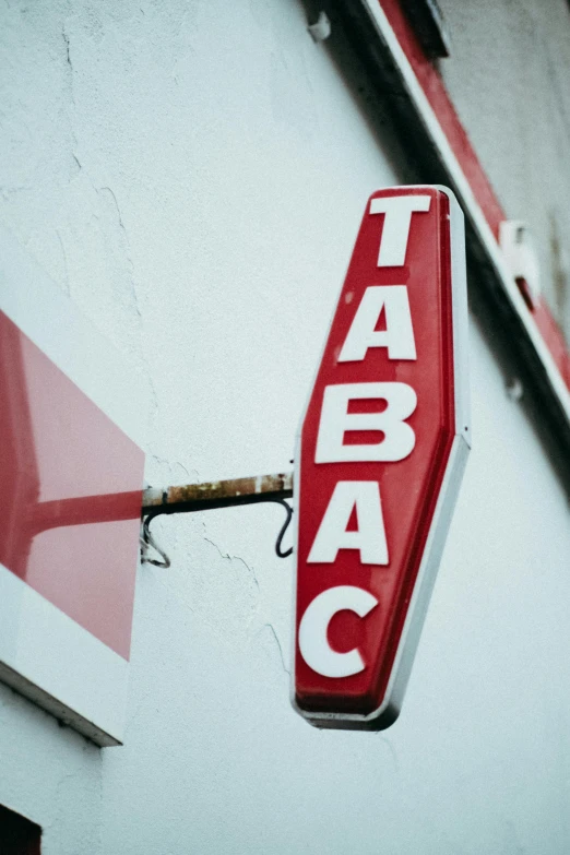 a taco sign hangs from the side of a building