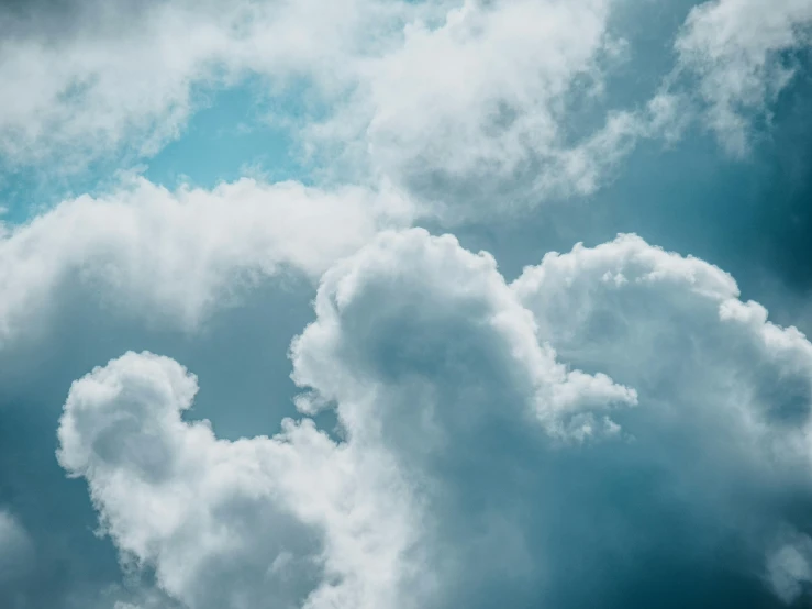 the airplane flies high through the cloudy sky