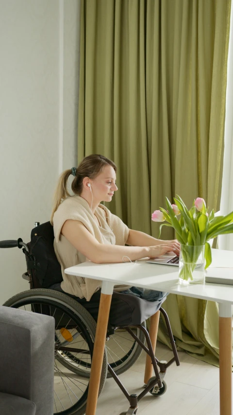 a person in a wheelchair is typing on their laptop