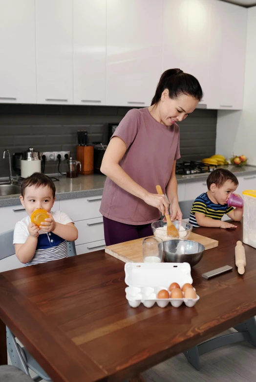 a woman stands behind two s, preparing food on a table